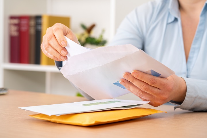 Close,Up,Of,Woman,Hands,Putting,A,Letter,Inside,An